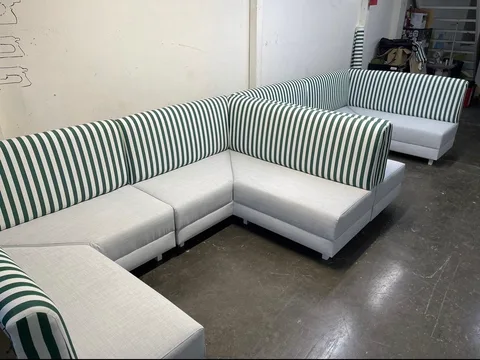 Striped backs and light cushions on modular corner seating in the US Booths workshop