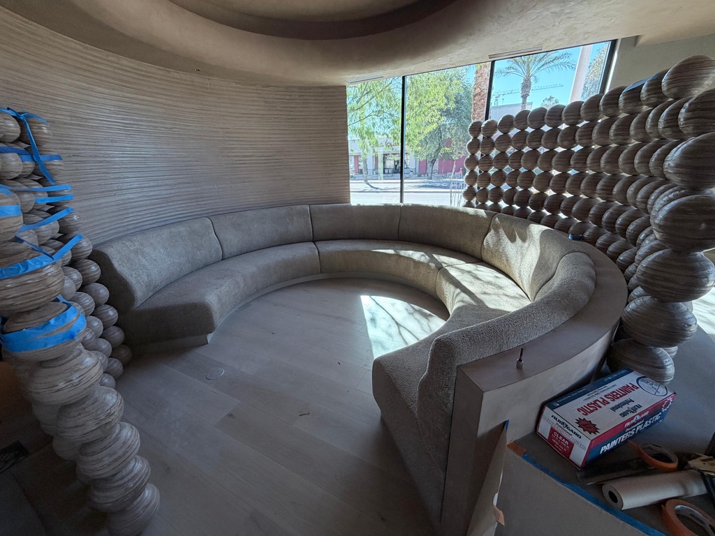 Circular upholstered booth and curved wood-frame fabrication for ATLAS Dreamhouse in Scottsdale