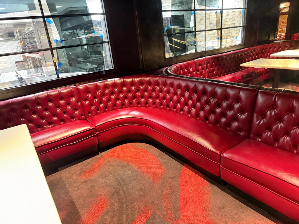 Red diamond-tufted booth seating and curved seat reupholstery at Durant’s in Phoenix