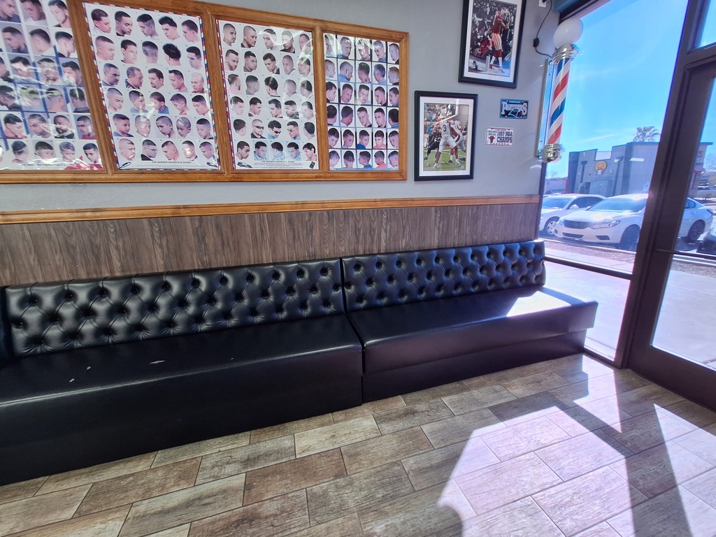 black tufted waiting bench installed — installed barbershop seating photograph