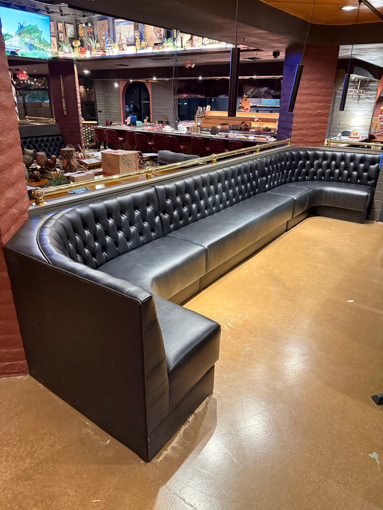 Black diamond-tufted seating with smooth cushions inside Night Owl in Tempe