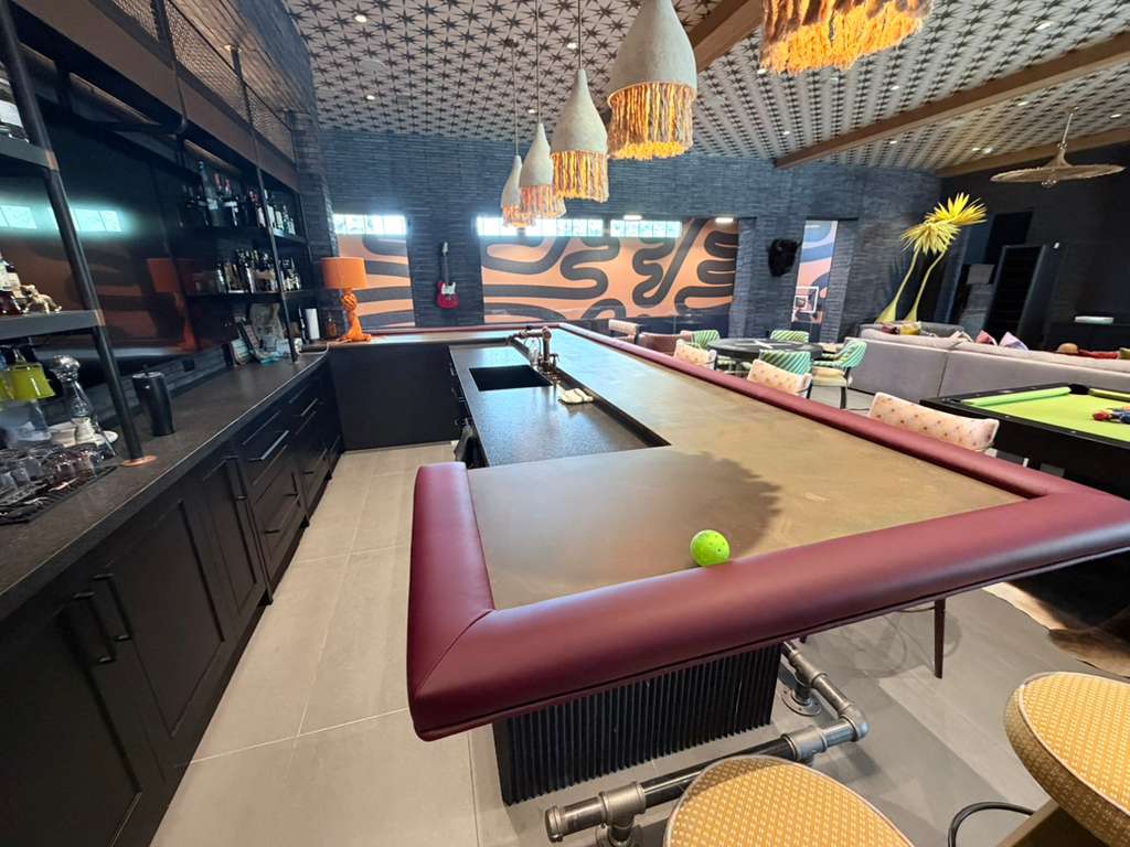 Burgundy leather upholstered rail around a residential home bar in Paradise Valley, in collaboration with Regal American Homes