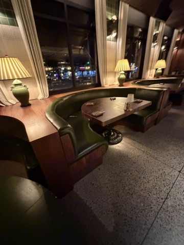 Green upholstered restaurant booths and curved banquettes with wood surrounds at The Henry on Second in Phoenix