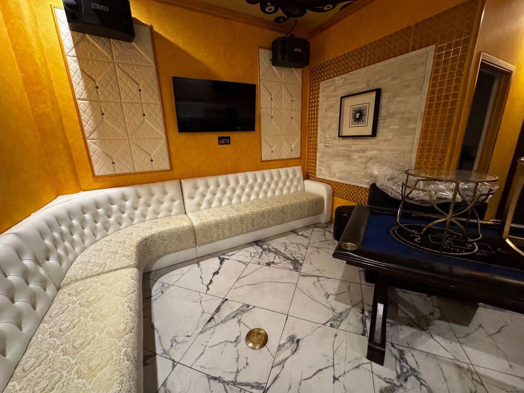 White diamond-tufted banquette backs and patterned seats in the yellow karaoke room at YZ Karaoke Cafe in Mesa