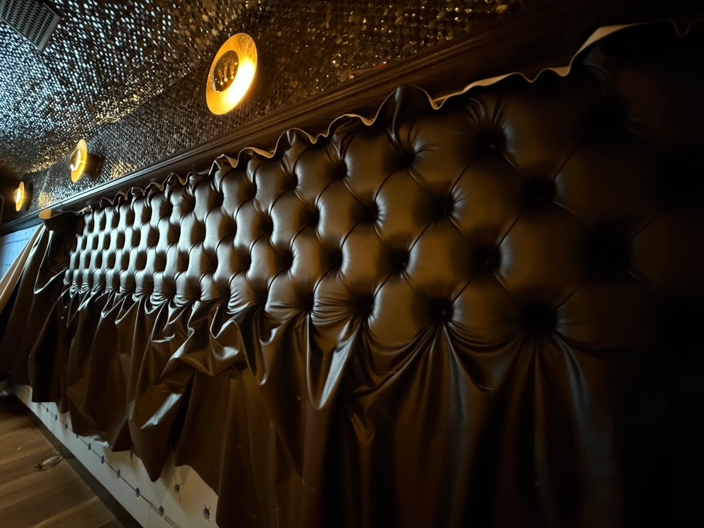 Diamond-tufted upholstery in progress in the US Booths workshop