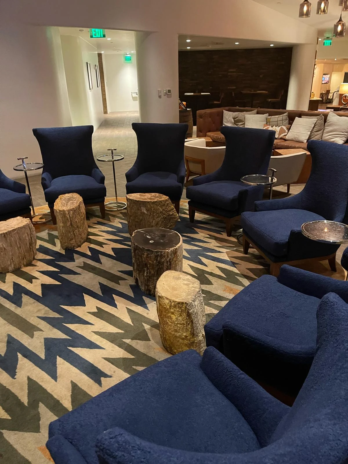 Blue upholstered lounge chairs arranged around tables in a hospitality lounge